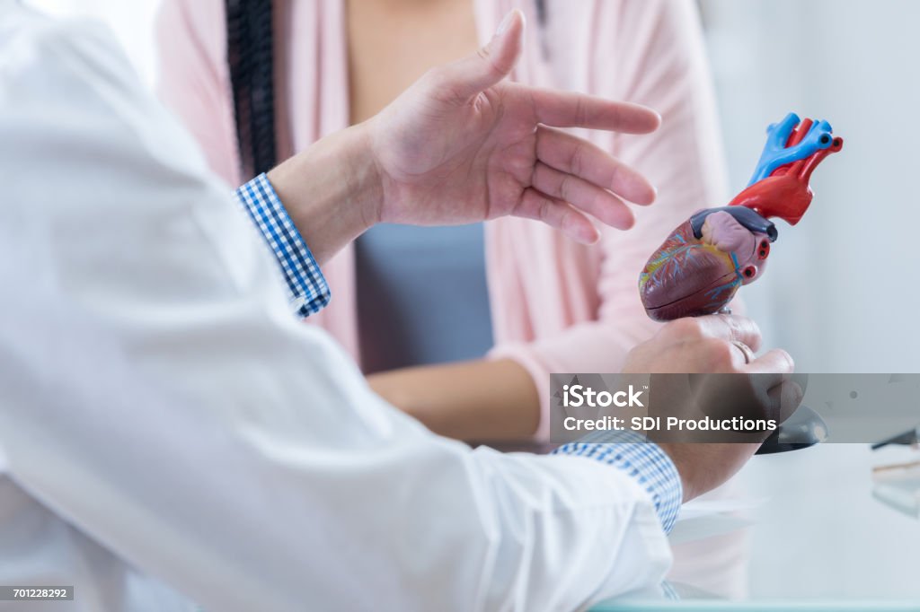 Männliche Kardiologe erläutert Diagnose mit Patienten - Lizenzfrei Kardiologe Stock-Foto