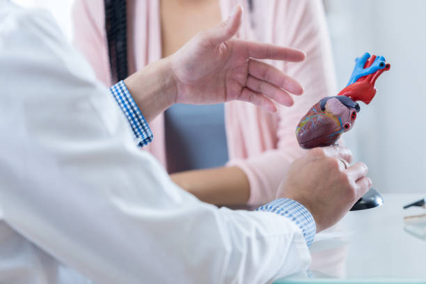 cardiólogo macho habla sobre diagnóstico con el paciente - cardiologist fotografías e imágenes de stock