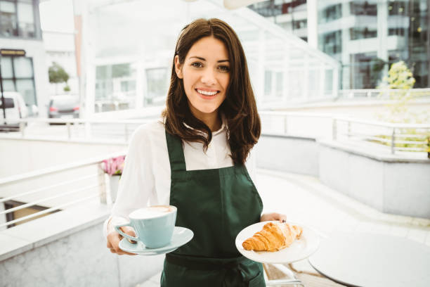 istock Waitress posing with coffee and croissant 701231364