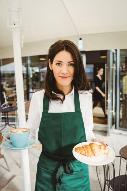 istock Waitress posing with coffee and croissant 701231370