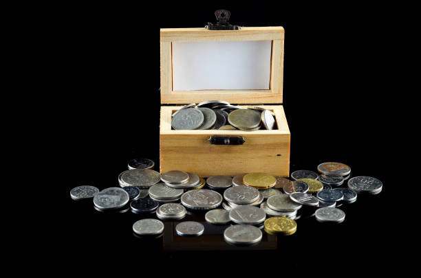 istock Malaysian coin in wood container box over black background 701244088