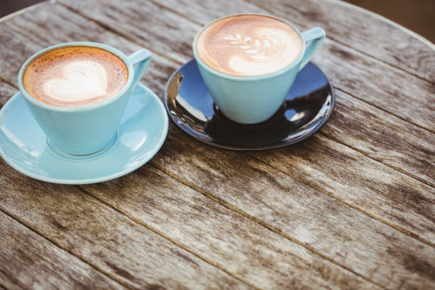 istock Cup of cappuccino with coffee art on wooden table 701249476
