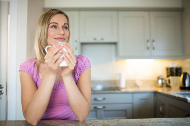 Pretty blonde woman having coffee at home