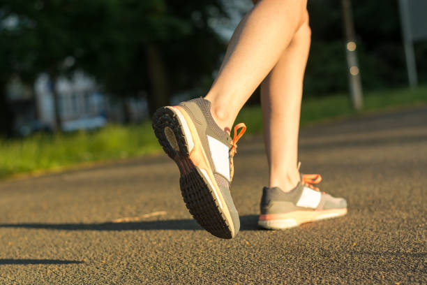 istock Runner with running shoes on tarmac from the side during sunset 701260604