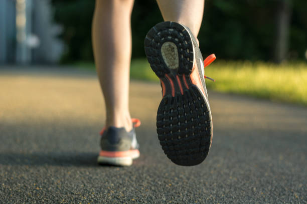 istock Runner with running shoes on tarmac from behind during sunset 701260654