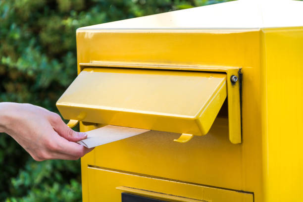 istock Throwing a letter in a german yellow mailbox 701260850