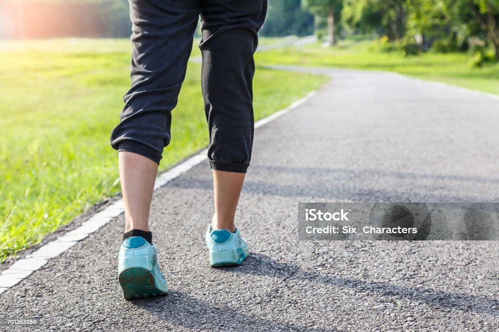 Closeup of female shoe runner feet running on road with nature background, fitness woman Racewalking Stock Photo
