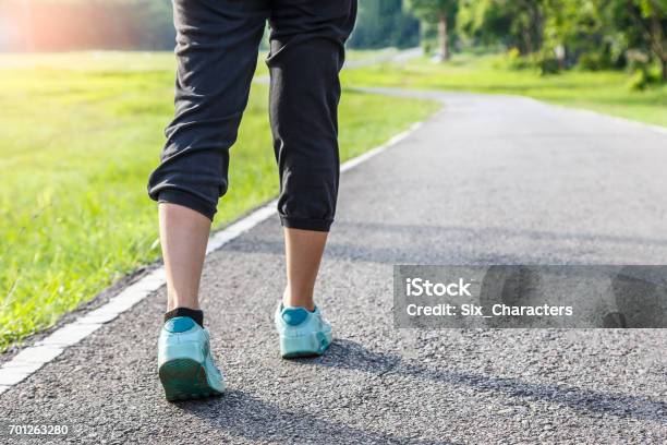 Closeup Of Female Shoe Runner Feet Running On Road With Nature Background Fitness Woman Stock Photo - Download Image Now