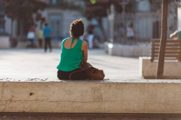 istock Rear View Of Woman Sitting On Retaining Wall 702608073