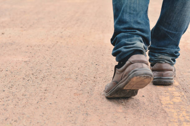 istock Low Section Of Man Walking On Footpath 702610777