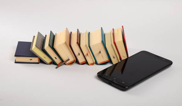 istock High Angle View Of Mobile Phone By Books On White Background 702612023