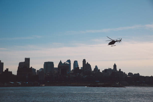 istock Silhouette Helicopter Flying Over East River Against Sky On Sunny Day 705169941