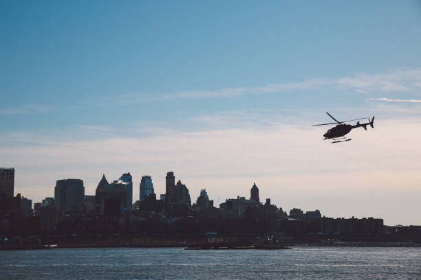 istock Silhouette Helicopter Flying Over East River Against Sky On Sunny Day 705178017