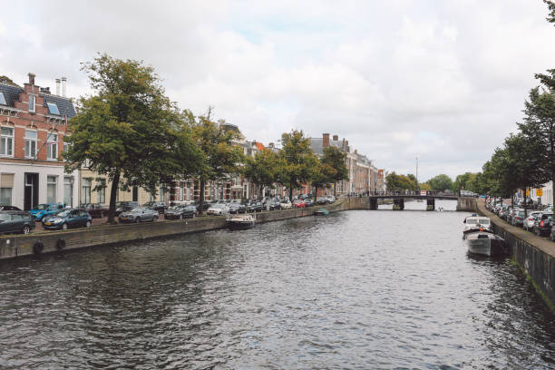 istock Canal Amidst Trees In City Against Cloudy Sky 705196751