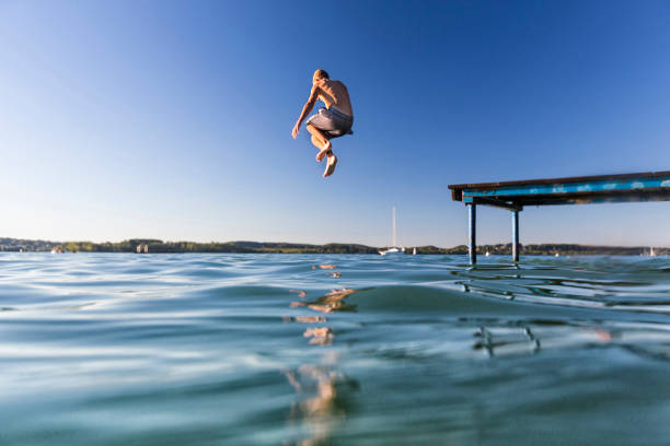 istock Man Jumping In Water Against Clear Sky 707550097