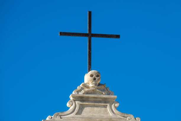istock Low Angle View Of Skull On Cross Against Clear Blue Sky 709182685