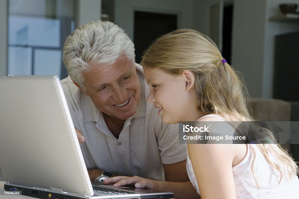 Chica joven con la computadora portátil y abuelos - Foto de stock de Abuelo libre de derechos