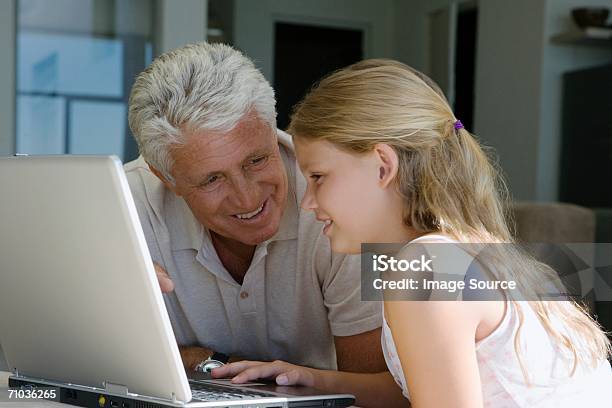 Foto de Young Girl And Grandparent Using Laptop e mais fotos de stock de Adulto - Adulto, Amor, Aprender