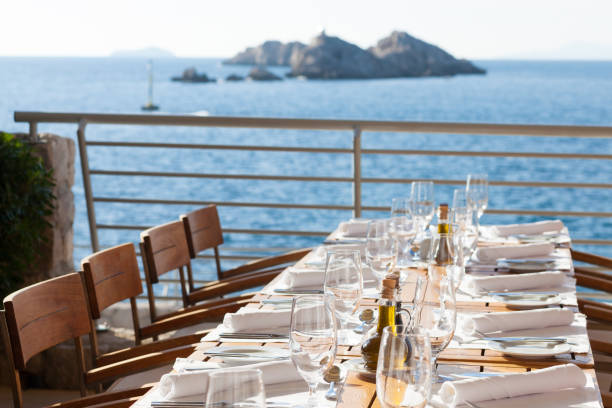 istock Chairs And Tables At Dining Table By Sea Against Sky 713983105