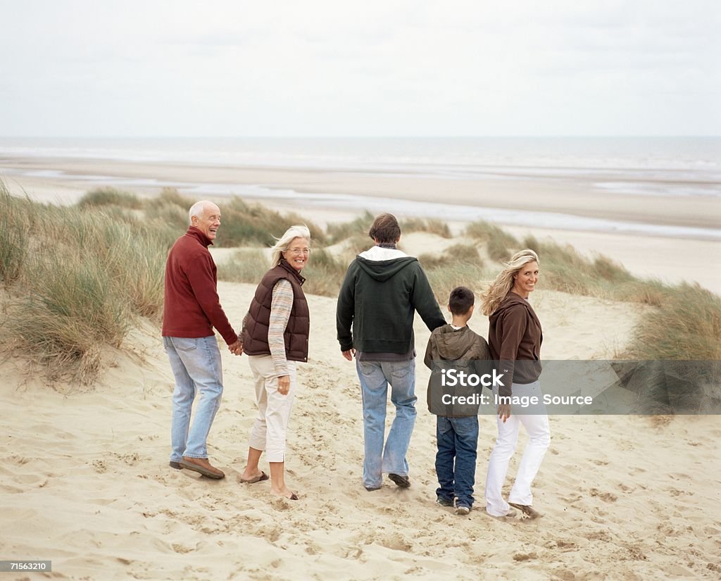 Семья прогулки вдоль пляжа - Стоковые фото Вид сзади роялти-фри