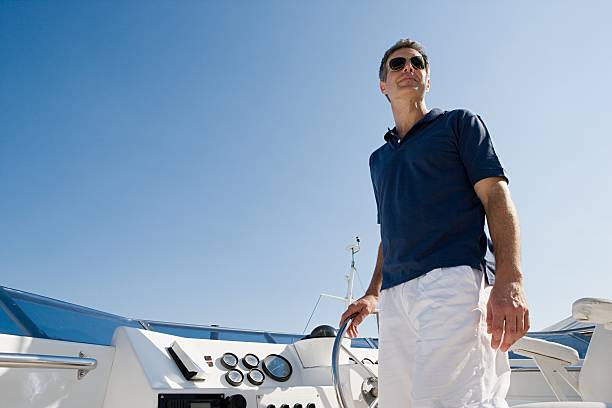 Man steering a yacht  luxury eyewear stock pictures, royalty-free photos & images