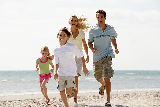 familie laufen am strand - family fun running couple stock-fotos und bilder