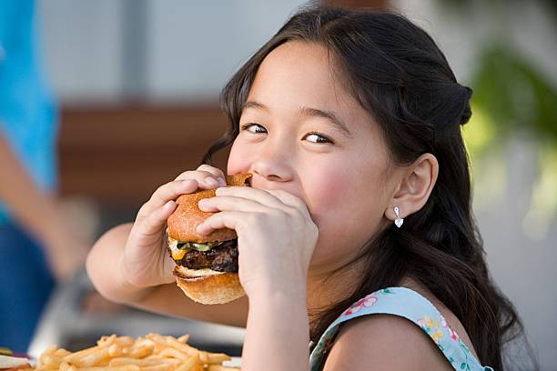 girl eating a burger - dining burger outdoors restaurant 뉴스 사진 이미지