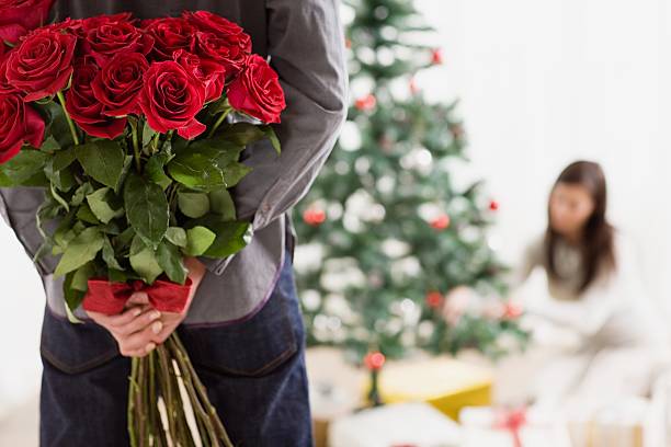 Man holding surprise gift of roses  rose christmas red white stock pictures, royalty-free photos & images