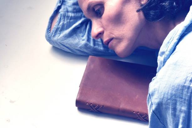 istock High Angle View Of Sad Woman With Bible Lying On Table 717357137