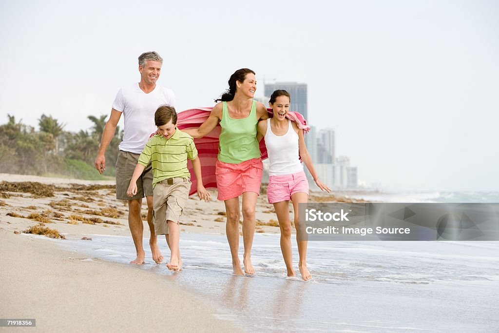 Familia caminando por la playa - Foto de stock de Familia libre de derechos