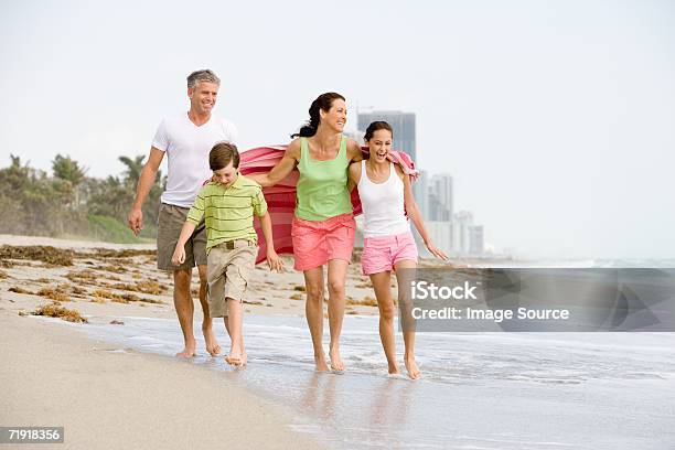 Familia Caminando Por La Playa Foto de stock y más banco de imágenes de Familia - Familia, Playa, Adolescente