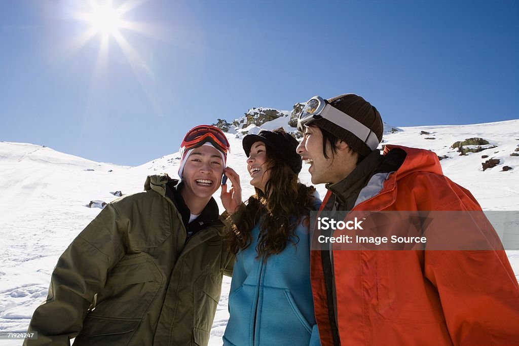 Snowboarders with cellular telephone  Ski Holiday Stock Photo