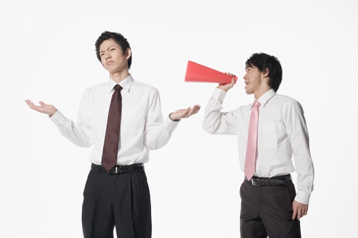 The adult Asian man with yellow shirt standing on the blue background.