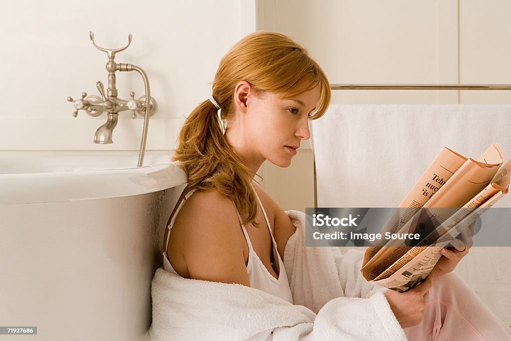 Femme lisant le journal offert dans la salle de bains - Photo de Adulte libre de droits
