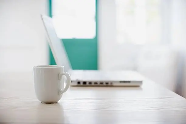 Photo of Coffee cup and laptop computer