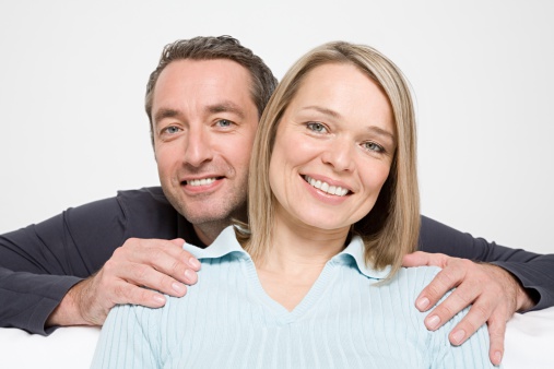 Family Ideas. Loving Calm Tranquil Caucasian Couple Standing Embrced Over White Background. Vertical Image