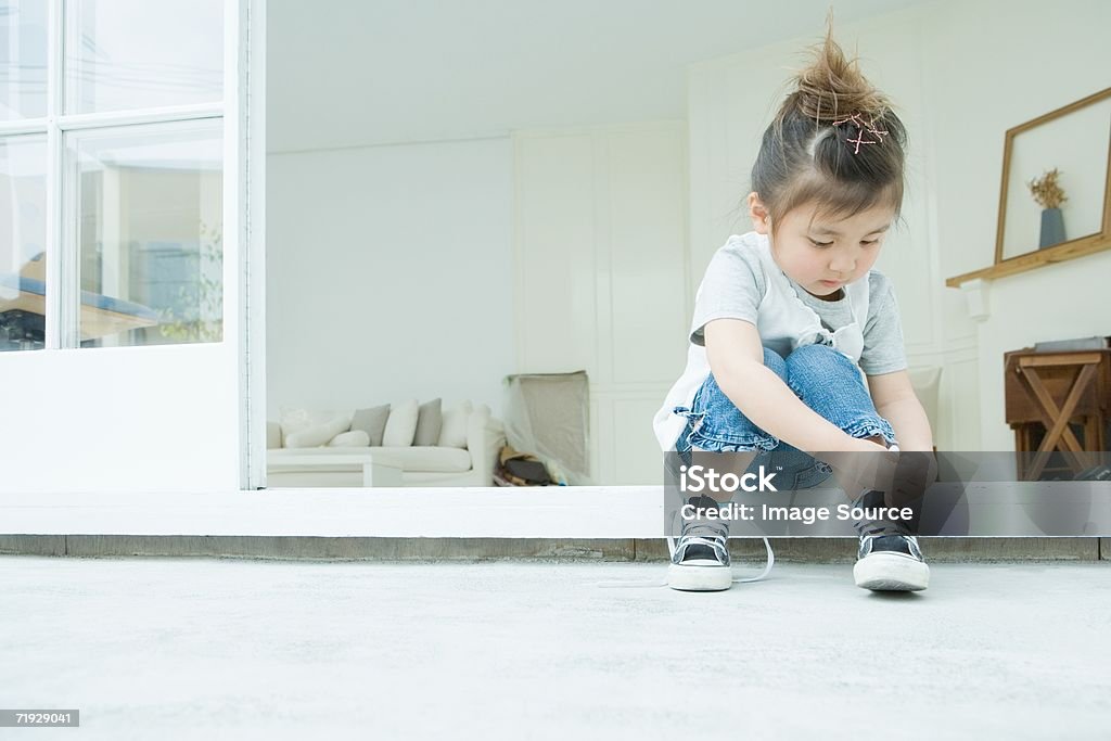 Girl learning to tie her shoelaces  Child Stock Photo