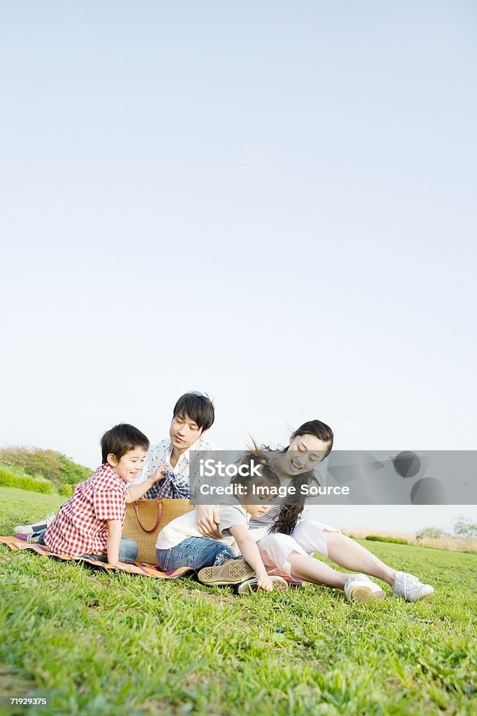 Asian family sitting in a field  Family Stock Photo