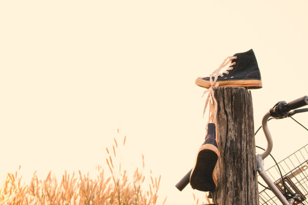 black  dirty children shoes \nbetween pebbles and straw