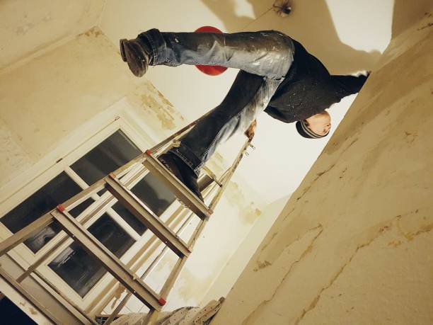 istock Low Angle View Of Man On Ladder Working At Home 720118475