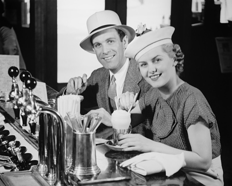 Hombre y mujer en el sombrero elegante beber gaseosa con helado photo