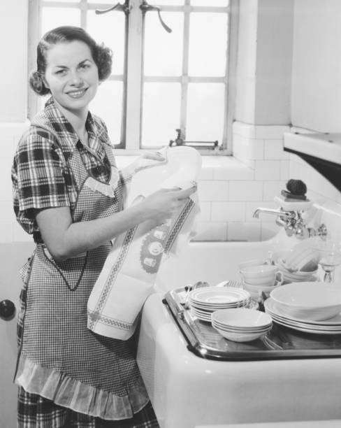 Young woman drying dishes in kitchen (B&W), portrait  washing dishes photos stock pictures, royalty-free photos & images