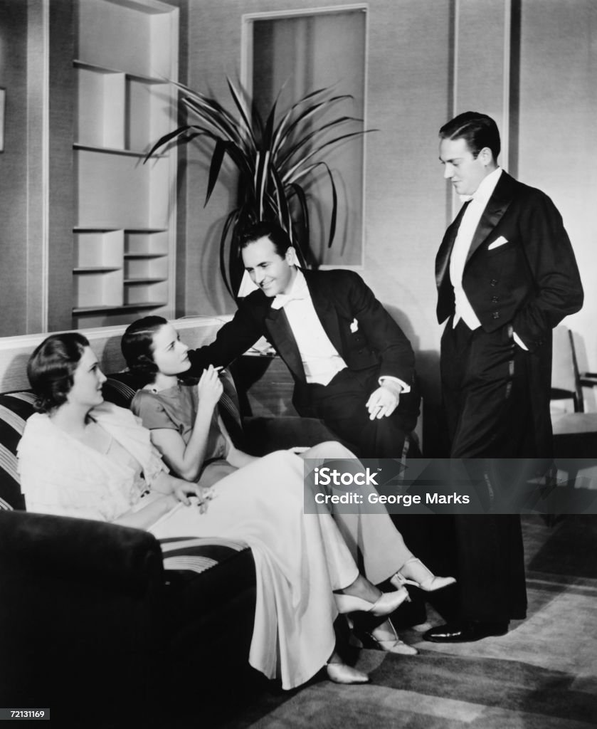 Personas en ropa de noche hablando en la sala de estar (B & P - Foto de stock de Blanco y negro libre de derechos