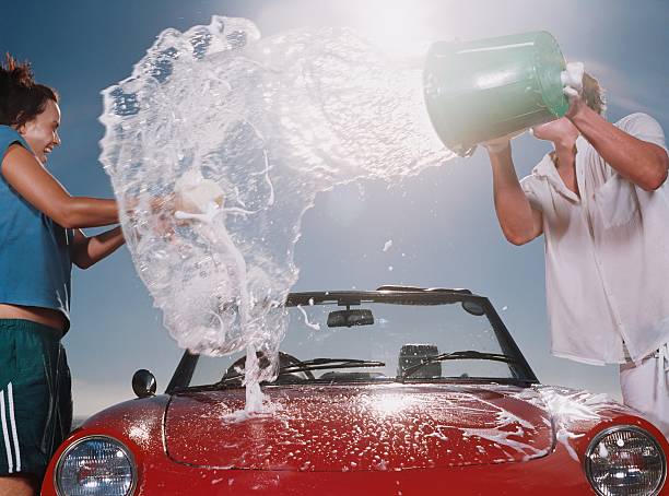 junge werfen seifenwasser zu mädchen - washing water car cleaning stock-fotos und bilder
