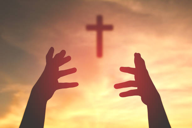 istock Cropped Image Of Silhouette Hands Catching Cross Against Sky During Sunset 726854183