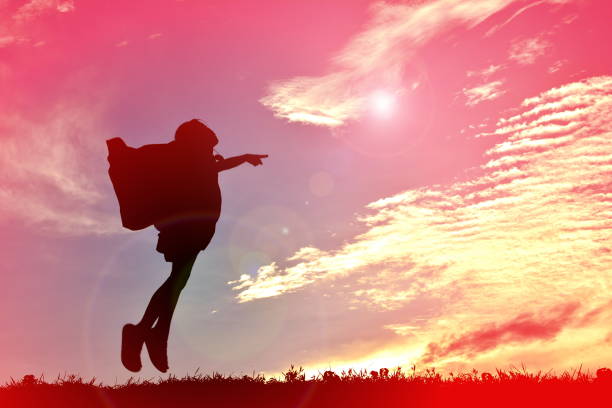 Silhouette of little girl during sunrise praying to god side view.
