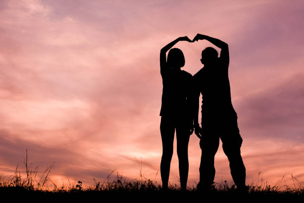istock Silhouette Couple Making Heart Shape Against Cloudy Sky During Sunset 726873279