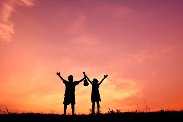 istock Silhouette Of Children With Ukelele At Sunset 726874657