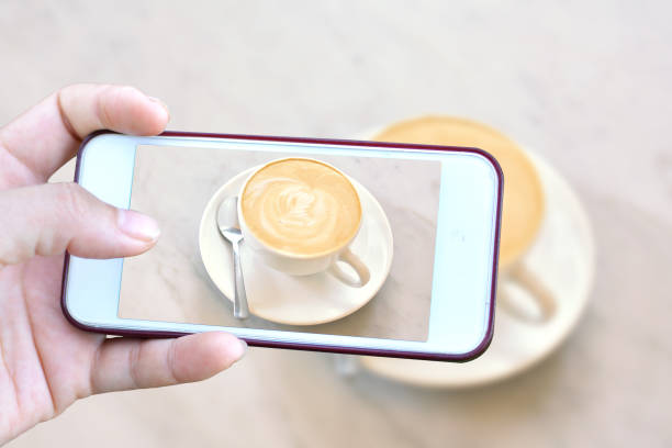 istock Cropped Hand Photographing Coffee Cup From Mobile Phone 726882621