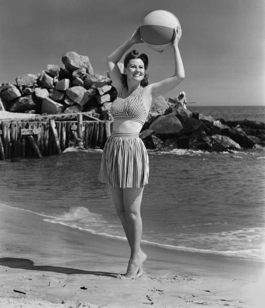 Woman holding ball on beach, (B&W)  vintage women stock pictures, royalty-free photos & images